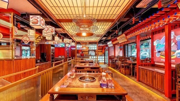 A restaurant with wooden tables and benches, a long counter, and a high ceiling with a fan. - Palon Hotel (Chongqing Xinpaifang) (Chongqing)