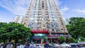 A multi-story building with a red awning and several ground-level shops. - Palon Hotel (Chongqing Xinpaifang) (Chongqing)