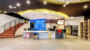 A modern hotel lobby with a curved reception desk, a staircase, and a seating area. - Palon Hotel (Chongqing Xinpaifang) (Chongqing)