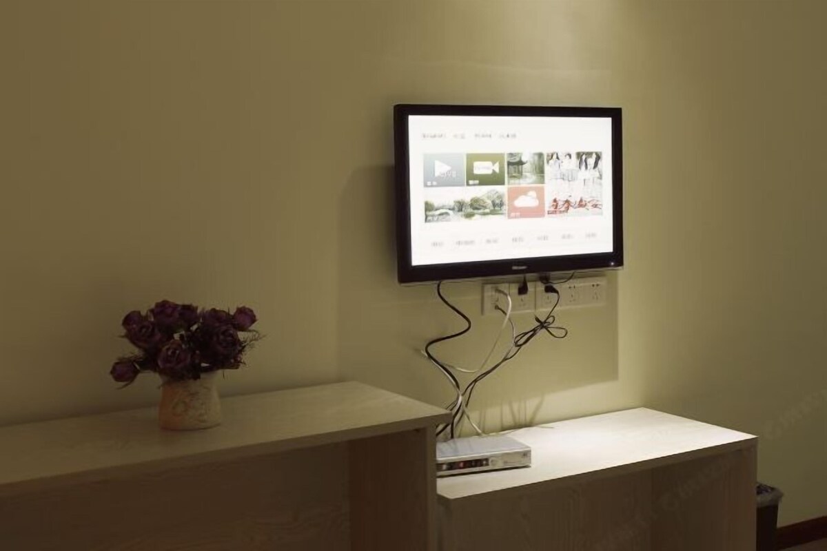 A flat-screen TV mounted on a wall displaying a media interface.