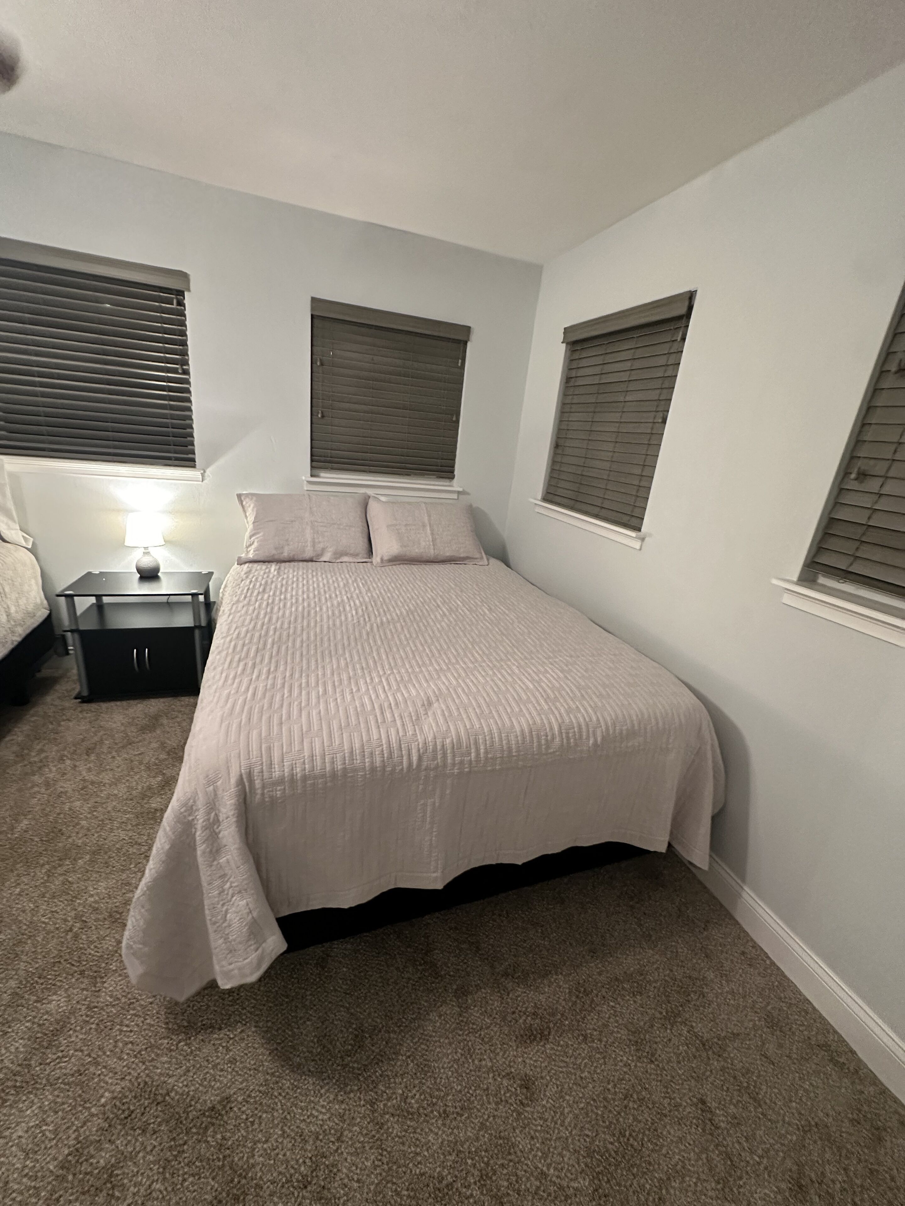 Une chambre à coucher avec un lit, une table de chevet et une lampe.