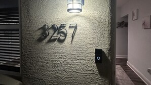 A textured wall with a number '3257' and a light fixture above it.