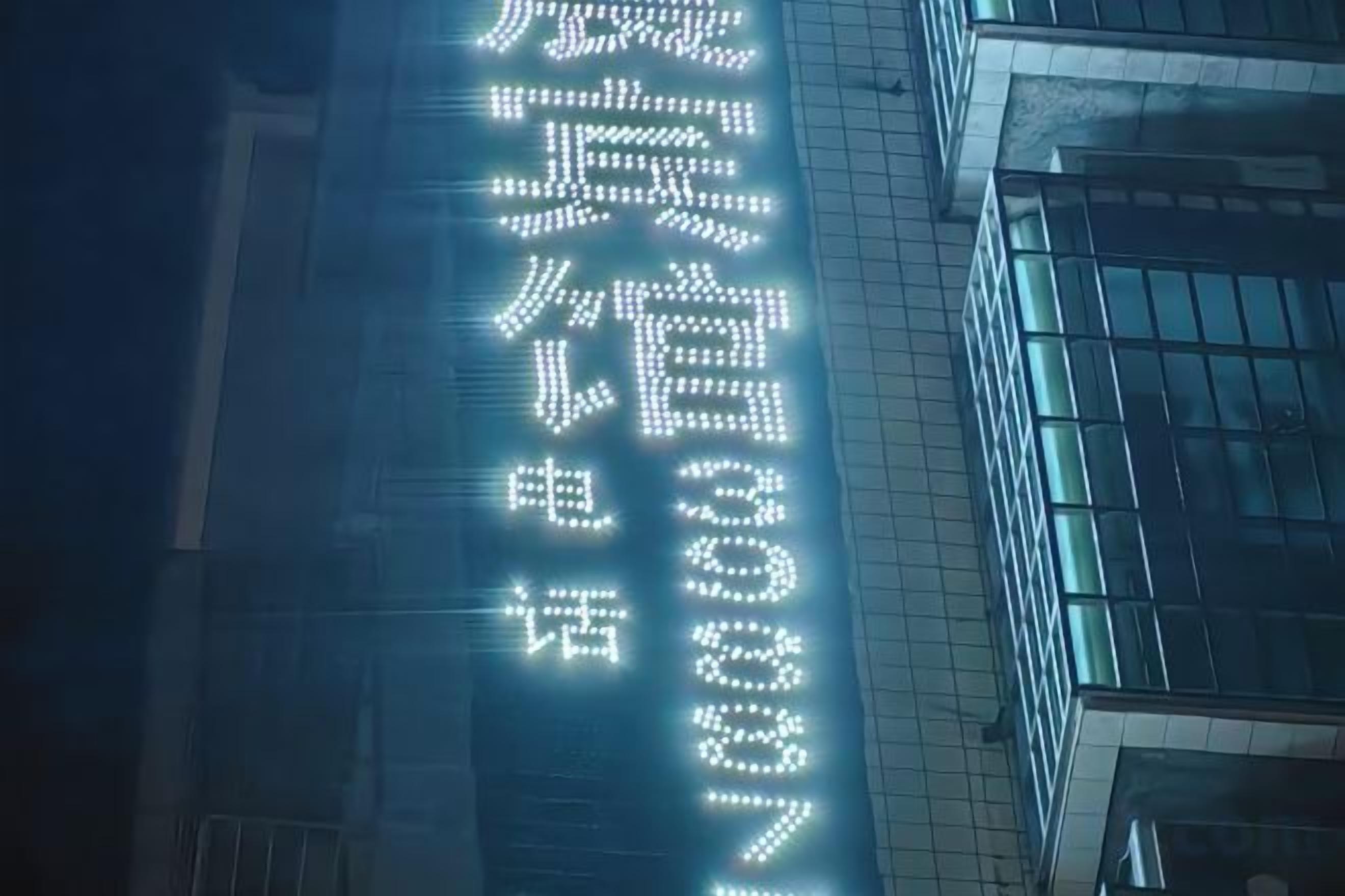 A building with illuminated signage, possibly a hotel or office, with a modern architectural style.