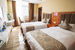 A hotel room with two beds, a desk with a chair, a small table, and a mirror. - Yi Long Hua Chen Impress Business Hotel (Yilong)
