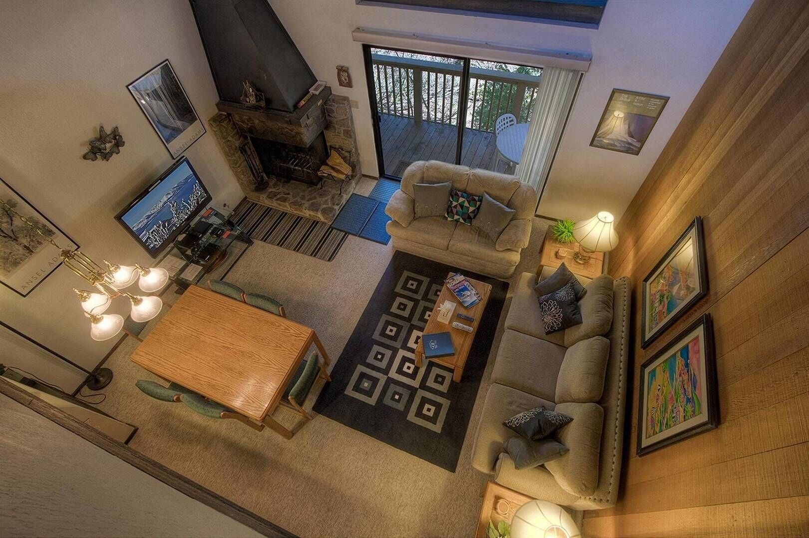 A spacious living room with a stone fireplace, a large window, and a cozy seating area.
