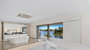Une salle de bain moderne avec une baignoire sur pieds, un grand miroir et une vue sur un lac.