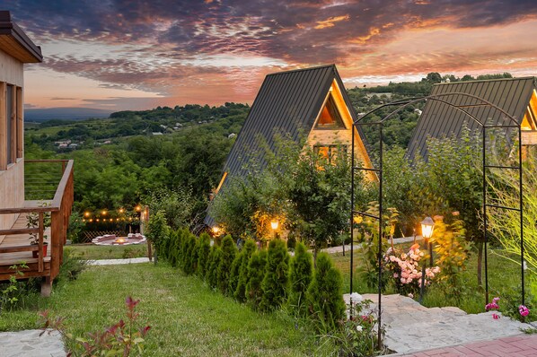A modern house with a sloped roof, a wooden deck, and a garden with a pathway.