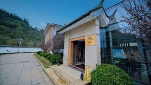 A traditional building with a tiled entrance and a modern glass extension. - Jiaozishan Resort Hotel (Luquan)