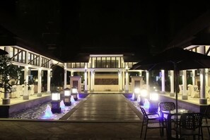 A hotel entrance with a water feature, outdoor seating, and a covered walkway. - Lotin Hot Springs Hotel (Gaozhou)