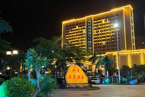 A hotel with a modern facade, illuminated by yellow lights, and a prominent sign in front. - Lotin Hot Springs Hotel (Gaozhou)