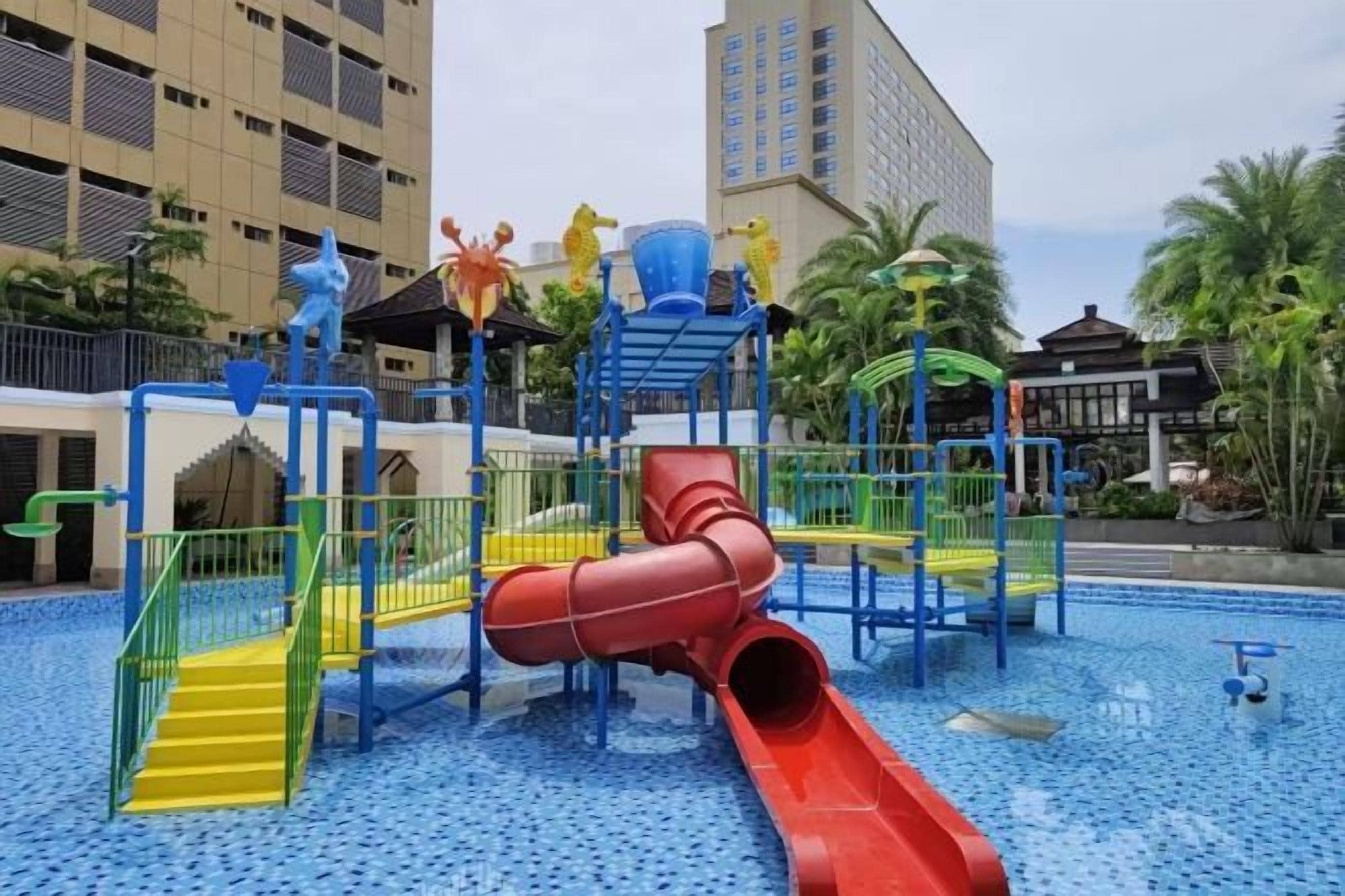A playground with a red slide and multiple play structures.