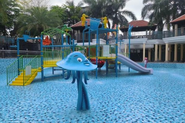 Un área de juegos infantiles con un tobogán y estructuras para escalar.