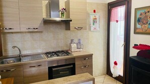 Eine Küche mit Gasherd, Backofen, Spüle und Holzschränken.