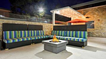 An outdoor seating area with two sofas and a fire pit.