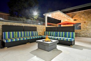 An outdoor seating area with two sofas and a fire pit. - Home2 Suites By Hilton Livermore (Livermore)