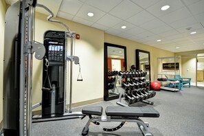 A gym with weightlifting equipment, a bench, and a mirrored wall. - Home2 Suites By Hilton Livermore (Livermore)