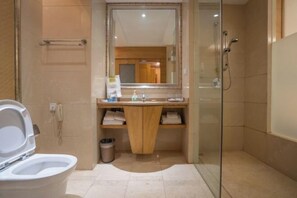 Baño con inodoro, lavabo, espejo y ducha.
