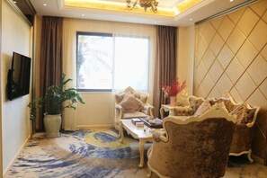 A spacious living room with a large window, a television mounted on the wall, and a decorative plant. - Island Hotel (Dongshan County)