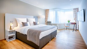 A modern bedroom with a large bed, bedside tables, a desk, and a chair. - Self Check-In Hotel Am Brinkerplatz (Essen)