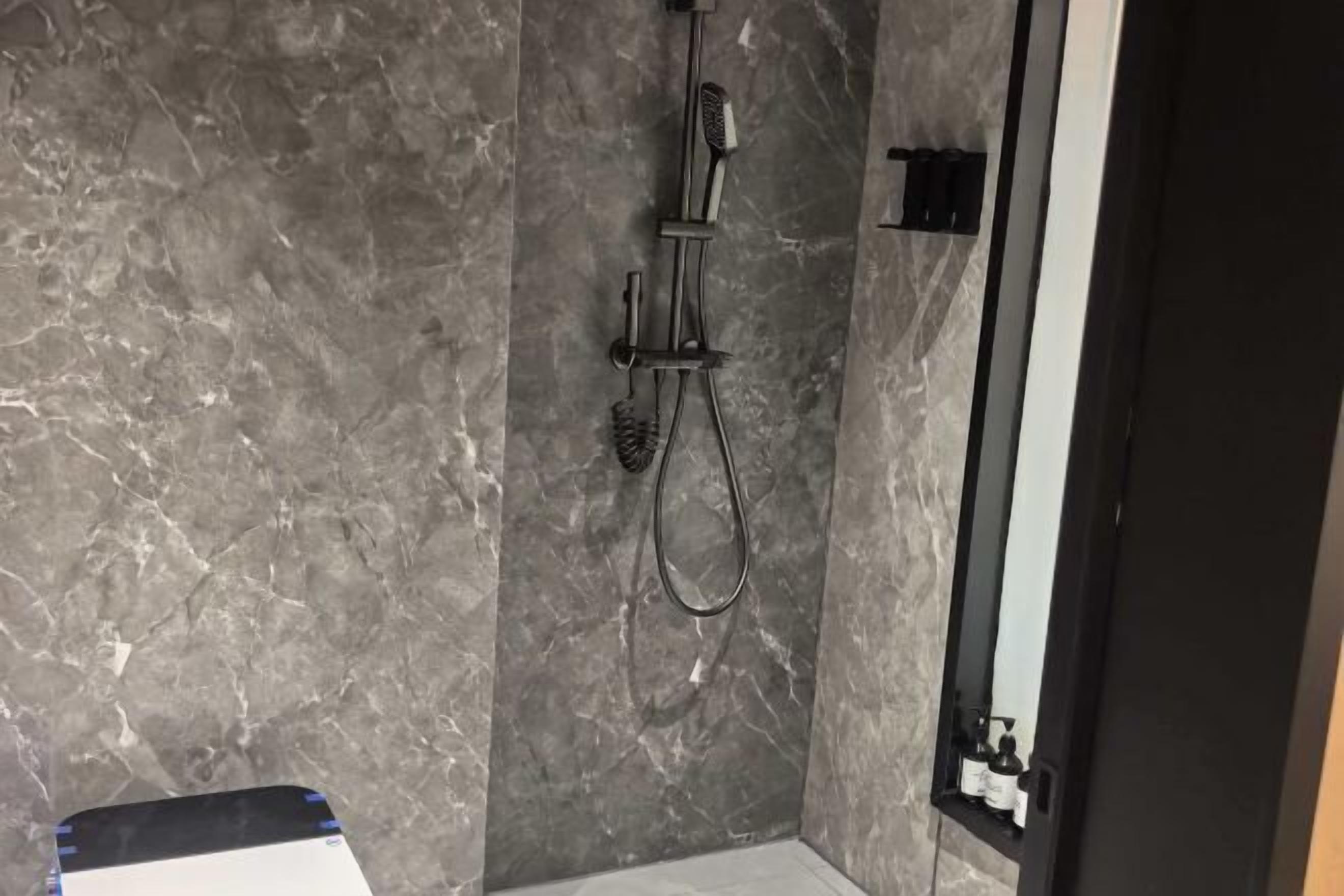 A bathroom with a shower, a mirror, and a sink.