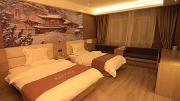 A hotel room with two beds, a large wall painting, a desk, and a sofa.