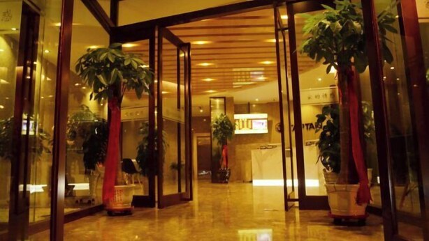 A hotel lobby with glass doors, potted plants, and a reception desk. - Captain Chain Hotel (Daixian Selected) (Dai County)