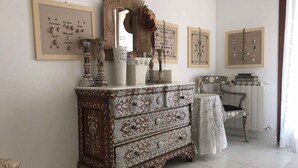 A room with a wooden dresser, a chair, and a mirror. There are framed pictures on the wall. - Holiday home mit Garten (Rosolina)