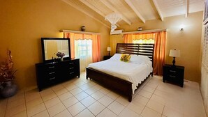 A bedroom with a bed, dresser, nightstands, and a ceiling fan. - Donhenri House Hodges Bay in Antigua (Saint John's)