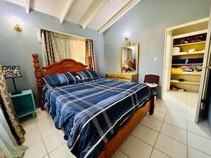 A bedroom with a wooden bed, a nightstand, a mirror, and a wardrobe.
