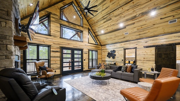 Un amplio salón con techo alto, ventanas grandes y chimenea.