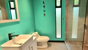 Un baño con inodoro, lavamanos y ducha.