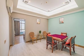 Een eetruimte met een tafel en stoelen, een plafondlamp en een wandairconditioner.
