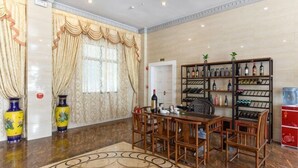 A dining area with a round table, chairs, a bar, and a wine rack. - Zhuxin Business Hotel (Huidong)
