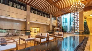 A spacious lobby with a large black water feature, seating areas, and a Christmas tree. - Tianmingshan Spa & Resort (Ninghai)