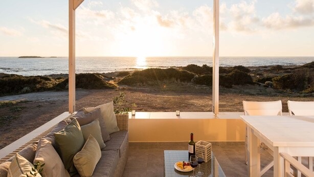 A covered outdoor seating area with a view of the sea at sunset. - Falasarna Seafront House (Kissamos)