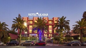 Un hotel con un letrero llamativo que dice "HOTEL AKABAR" y un letrero de restaurante-bar debajo.