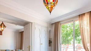 Un dormitorio con cama, sofá, mesa de comedor y una araña.
