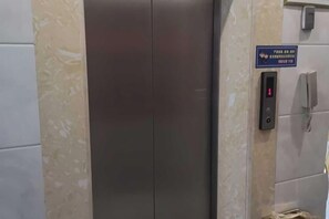 An elevator with a digital display and a sign above it. - Junyue Hotel (Dong'an)