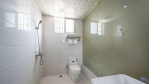 A bathroom with white tiles, a toilet, a shower, and a bathtub. - Junyue Hotel (Dong'an)