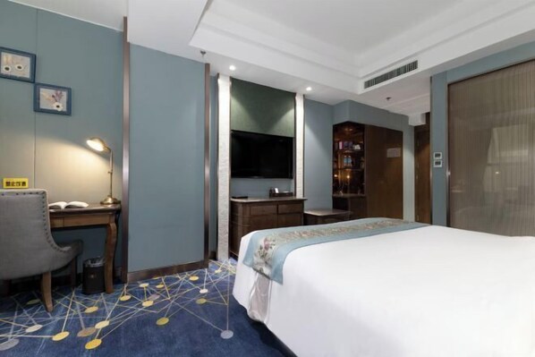 Une chambre d’hôtel équipée d’un lit, d’un bureau, d’une chaise et d’un téléviseur.
