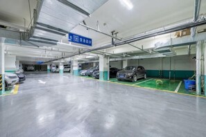A multi-level parking garage with several cars parked, clear signage, and a clean, well-maintained floor.