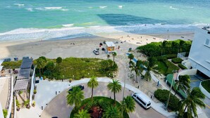A beachside hotel with a view of the ocean, a parking area, and a landscaped courtyard with palm trees. -  Lyfe Resort & Residences (Hollywood)