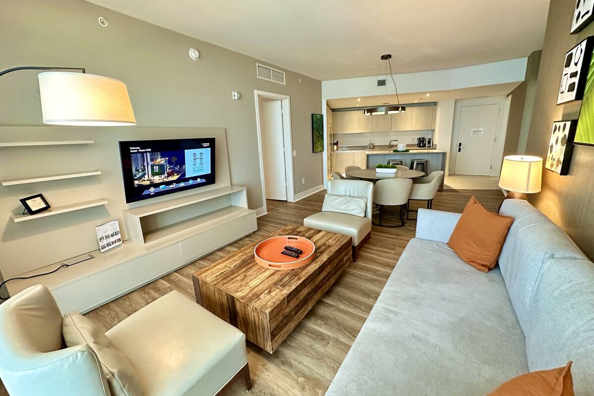 A modern living room with a flat-screen TV, a wooden coffee table, and a sofa.