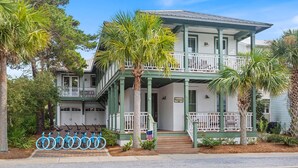 A two-story house with a balcony, a porch, and a garage. - Hemingway at 30A - Seacrest, 12,000 Sq Ft Community Pool, Beach Tram, Bikes! (Seacrest Beach)