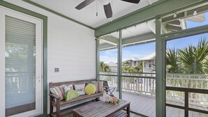 A covered porch with a wooden bench and cushions, a ceiling fan, and a view of neighboring houses and palm trees. - Hemingway at 30A - Seacrest, 12,000 Sq Ft Community Pool, Beach Tram, Bikes! (Seacrest Beach)
