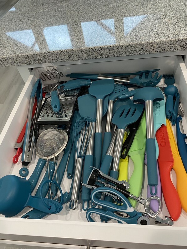 Un cajón lleno de diferentes utensilios y herramientas de cocina.