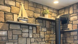 A stone wall with a fireplace, a ship model, and a potted plant. - Casa Calypso-10 minutes to Newport and Narragansett. Walk to beach! (North Kingstown)