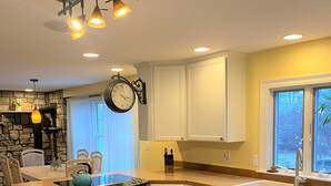 A modern kitchen with white cabinets, a built-in stove, and a large island. - Casa Calypso-10 minutes to Newport and Narragansett. Walk to beach! (North Kingstown)