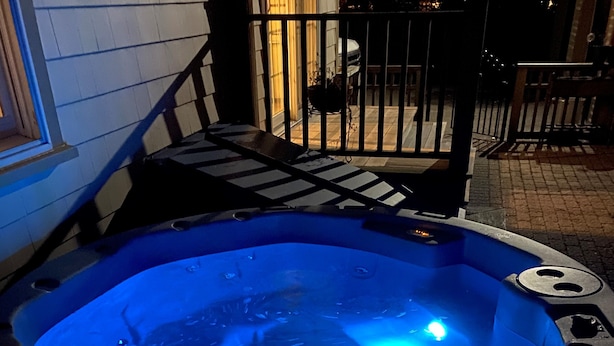 A hot tub with a blue light, a staircase, and a railing. - Casa Calypso-10 minutes to Newport and Narragansett. Walk to beach! (North Kingstown)