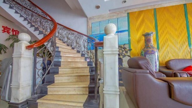 A grand staircase with ornate railings and a modern living area with leather sofas and a decorative vase. - Yingbin Hotel (Rui'an)